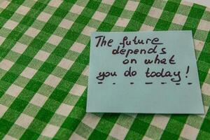 Motivational note placed on checkered tablecloth for daily inspiration photo
