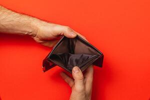 Financial struggle is evident as a man inspects his empty wallet photo