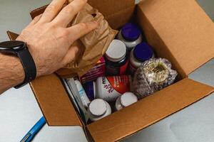 Lviv Ukraine 10.04.25 Unpacking a delivery of vitamins and supplements at home photo
