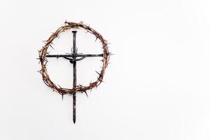 A crown of thorns encircles a simple black metal cross, photo