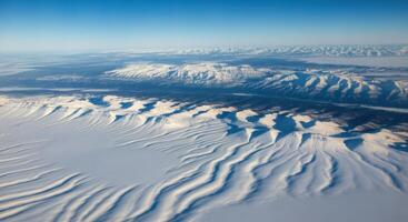 Aerial View of SnowCovered Mountains, Windswept Plains, and Arctic Landscape photo