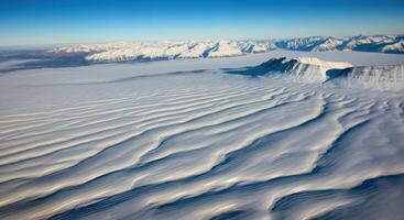 Aerial View of Arctic Snowdrifts, Windswept Plains, and Snowy Mountains photo