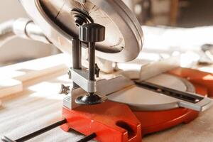 Circular saw in use cutting wooden plank inside workshop. The image highlights the precision and efficiency of the tool, emphasizing its role in woodworking projects and carpentry. photo