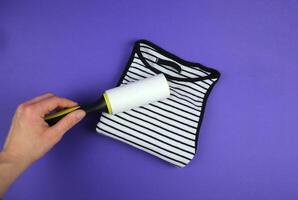 A woman's hand using a clothes roller to keep a folded T-shirt clean photo