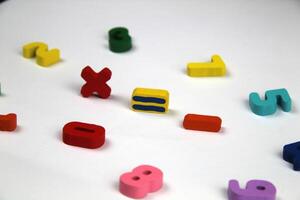 On a white background there are mathematical signs, in a crumpled shape of numbers. The concept of education and school. photo