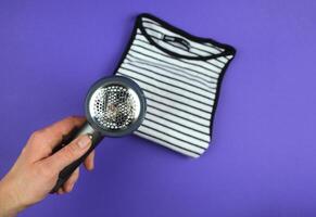 A woman's hand is about to clean lint from clothes. photo