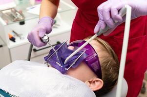 Child receiving dental care in a bright clinic with advanced tools and a caring professional ensuring a comfortable experience during a routine check-up photo