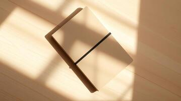 A notebook on a wooden table with sunlight shining through photo