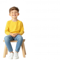 A cheerful boy in a yellow sweater and jeans sitting on a stool, smiling brightly. The image has a playful vibe, ideal for children's related content. png