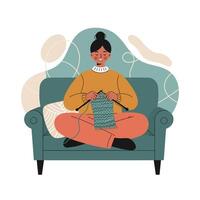 Woman sitting on green sofa knitting blue fabric in cozy relaxed home environment with casual outfit and bun hairstyle vector