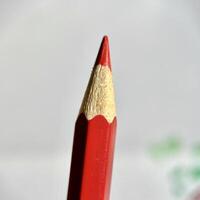 Close up red colored pencil stationary tip isolated on square paper surface background. photo