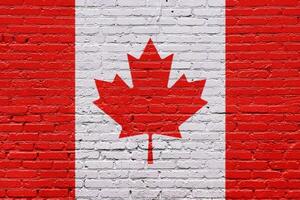 Canadian flag painted on a brick wall with a grunge texture and waving effect, showcasing the iconic maple leaf symbol in red and white photo