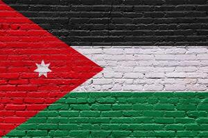 Grunge flags of jordan on a textured brick wall with patriotic symbols and abstract patterns photo