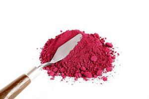 Bright Red Powder Spills From a Container on a White Surface Creating a Vibrant Display photo