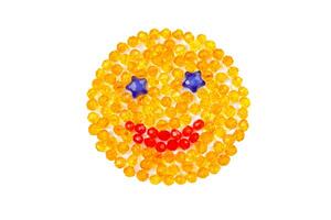 Smiling yellow smiley with beads on a white background. photo
