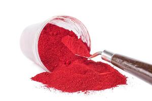Bright Red Pigment Spilled From Container With a Spatula photo