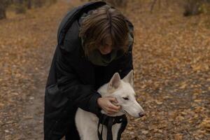 A woman strokes her white dog in the park on a morning walk photo