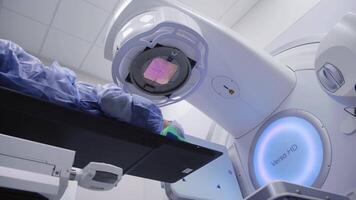 Man patient in the oncology room of the computed tomography department is being prepared by specialists to diagnose the exact location of the tumor in her brain. Medicine concept, technology video