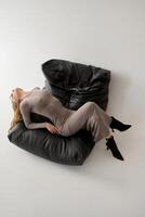 High angle view of businesswoman sleeping on bean bag chair in office photo