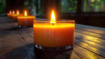 A glowing candle on a wooden table. photo