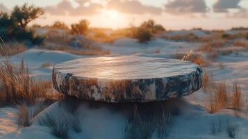 A flat stone table in a sandy landscape at sunset. photo