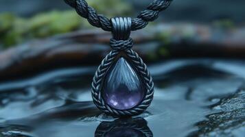 A pendant featuring a teardrop amethyst stone. photo