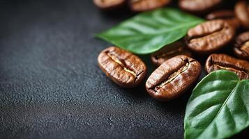 Coffee beans with green leaves on textured surface. photo