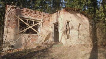 An old abandoned structure featuring boarded windows, encircled by nature, vividly illustrating neglect and decay video