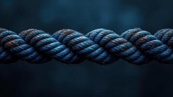 Close-up of intertwined blue rope against a dark background. photo