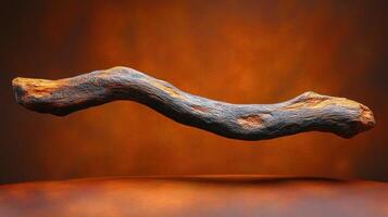 A textured, floating stick against a warm background. photo