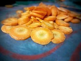 Freshly Sliced Carrots on Table. A pile of freshly sliced carrots is spread on a table, showing their bright orange color and fresh texture. photo