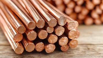Copper rods stacked on a wooden surface. photo