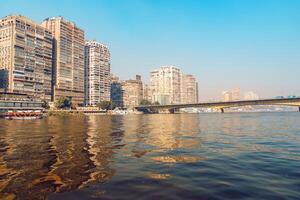 Skyline of Cairo along the Nile River during clear skies reflecting vibrant colors and modern architecture photo