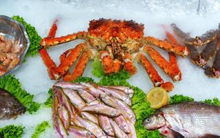 Fresh seafood display featuring crab and various fish at a market in the afternoon photo