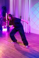 Dancer showcases expressive movement in a vibrant studio with neon lighting during a creative session photo