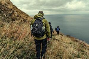 Hiking along a coastal trail with cloudy skies in the background on an overcast day photo
