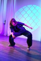 Dancer performing a creative movement in a modern studio with colorful lighting photo