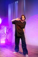 Dancer performing in a stylish studio with colorful lighting and artistic fog photo