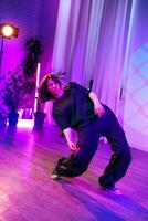 Dance performance capturing dynamic movement and expression in an artistic studio environment with colorful lights in the evening photo