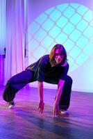 Dynamic dancer performs an expressive routine in a colorful studio setting with vibrant lighting effects photo