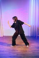 Dancer expresses creativity during solo performance in a vibrant studio setting with colorful lighting photo