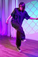 Dancer performing creatively on stage with colorful lighting at a contemporary art event photo