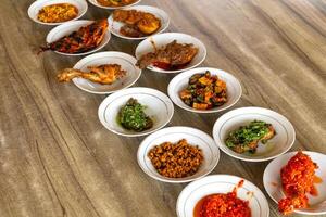 Typical Minangkabau food served on a table in a restaurant photo