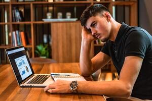A tired and bored student while studying inside university library. photo