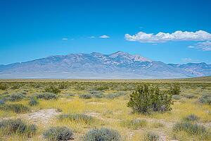 Majestic Mountain Range under a Clear Blue Sky. A panoramic view of a desert landscape with a breathtaking mountain backdrop. photo