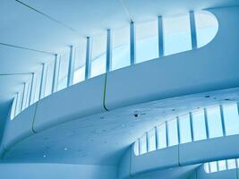 The ceiling of a vast building that features numerous windows photo