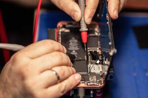 Repairing a smartphone battery with precision tools to ensure optimal performance during a busy afternoon at a tech repair shop photo