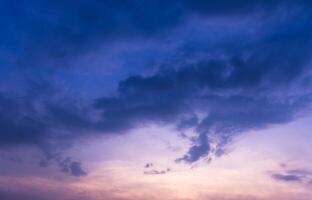 A captivating image of a deep blue sky, highlighted by soft, hazy clouds at sunset. photo