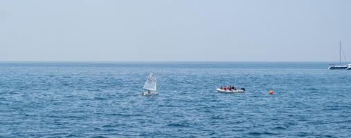 Sailing and recreational boating on a calm day in the open ocean with distant sailboats visible on the horizon photo