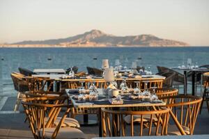 A cozy yet elegant oceanfront dining experience, with set tables and glassware photo